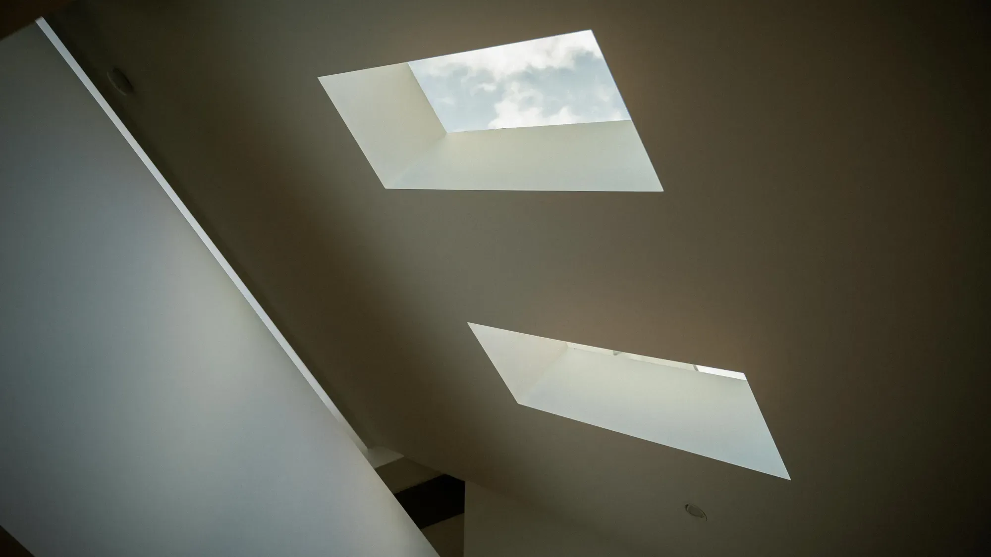 Two skylights cut into a sloped white ceiling