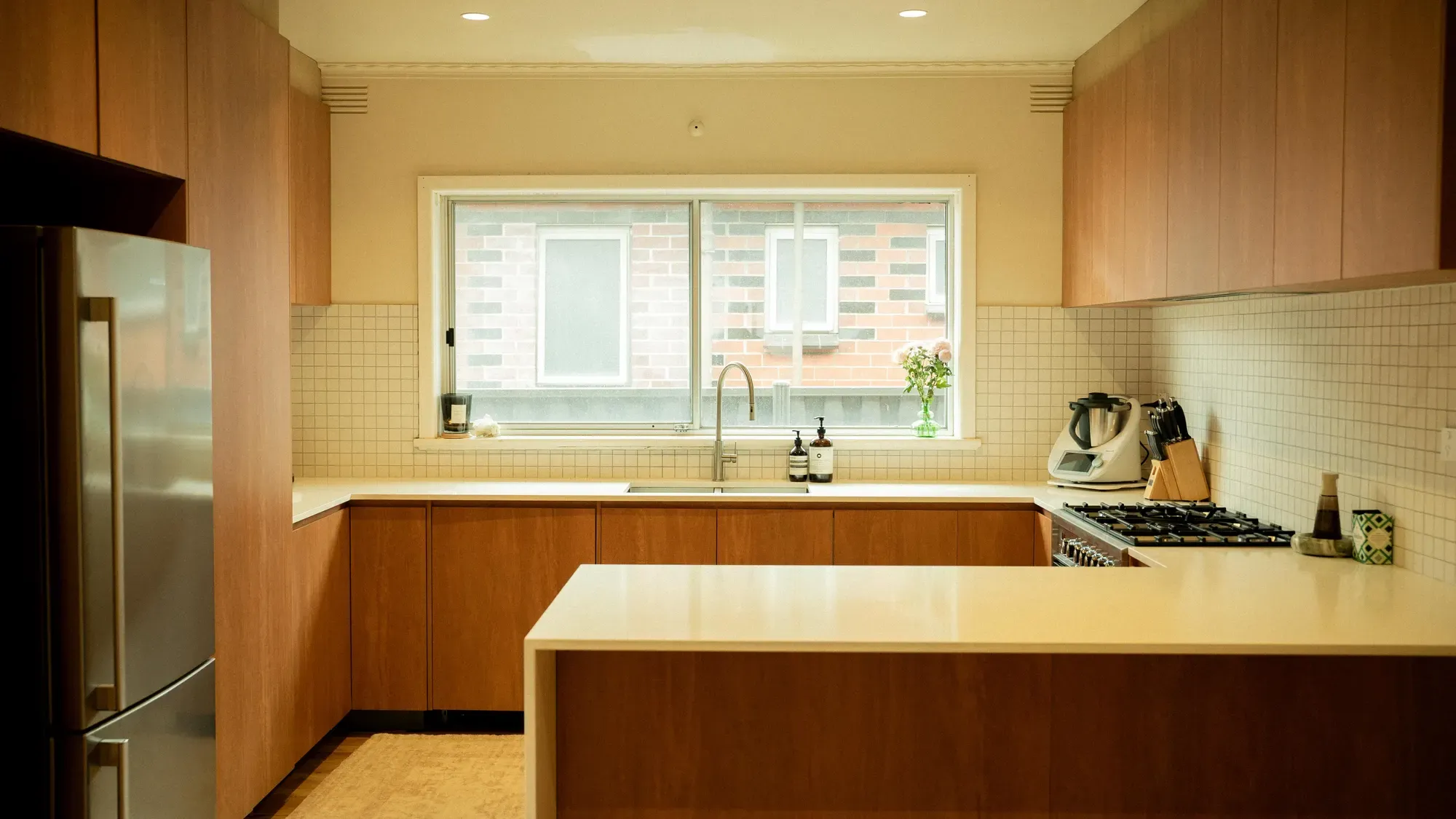 The kitchen in warm timber cabinetry, looking out over the sink