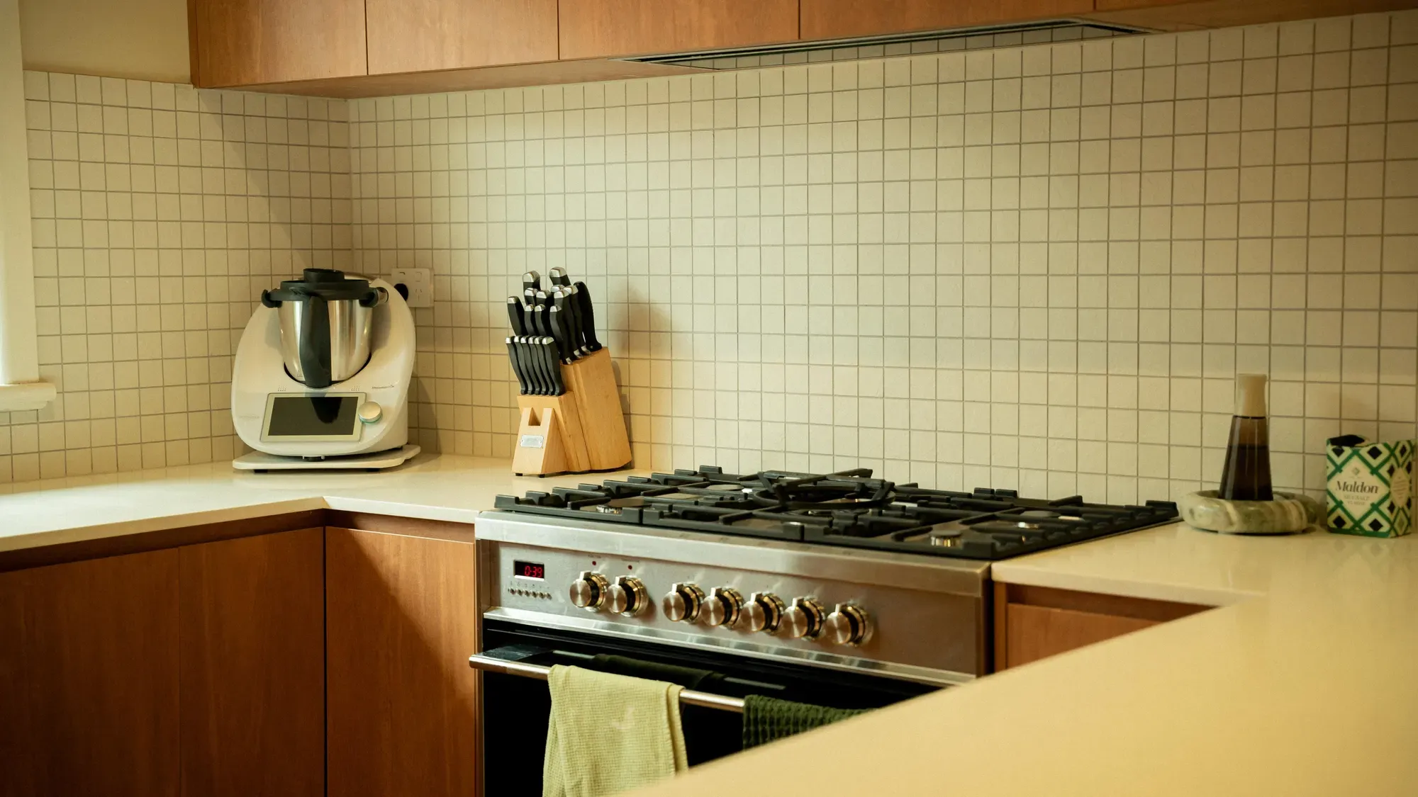 The gas range against a white tiled splashback