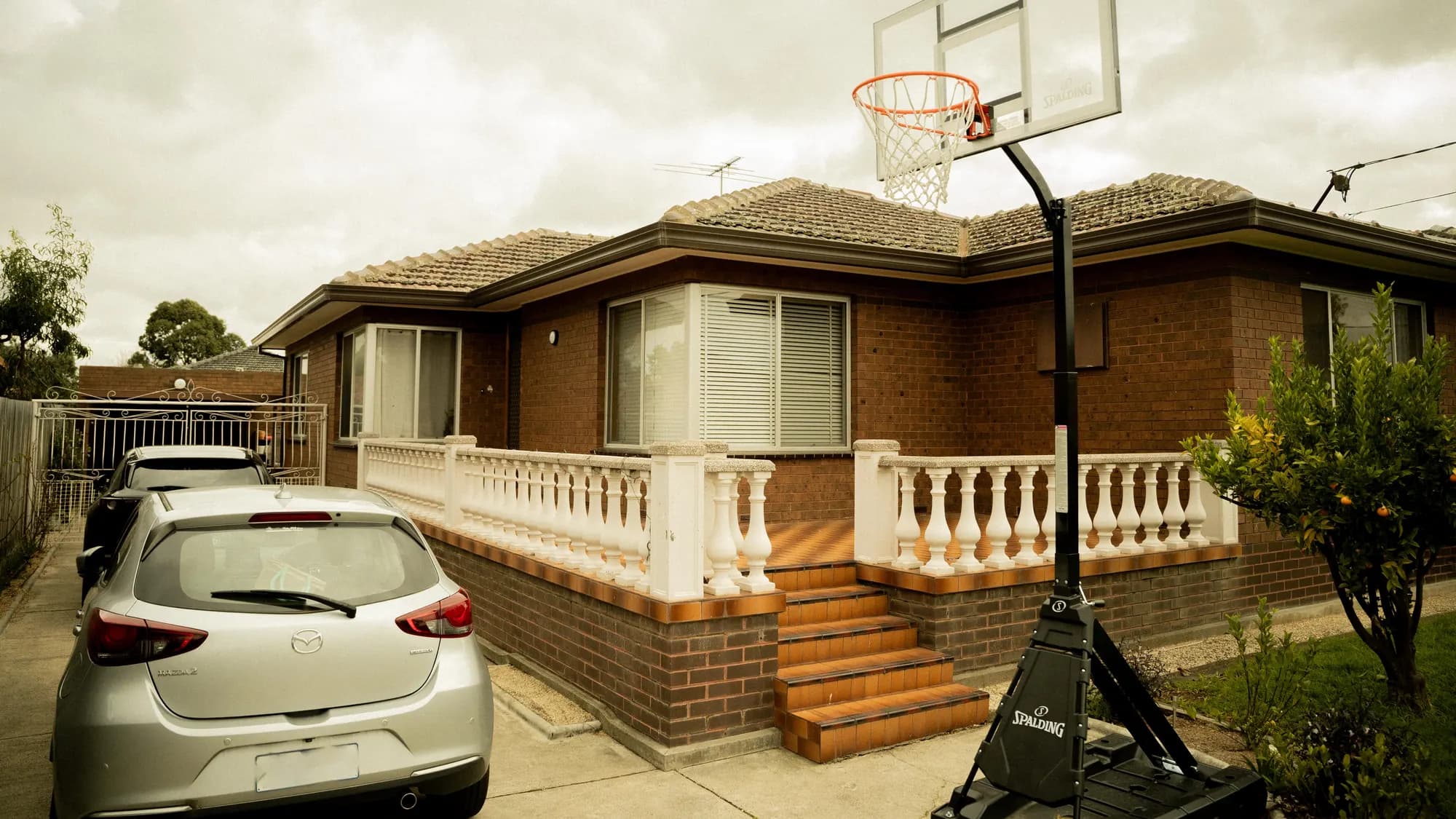 A red-brick bungalow behind a white balustrade