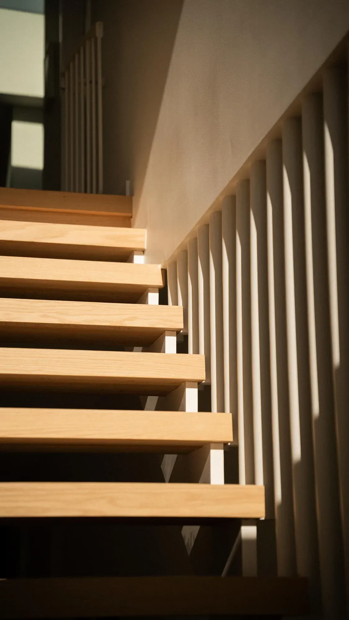 An open-tread timber stair behind a slatted balustrade