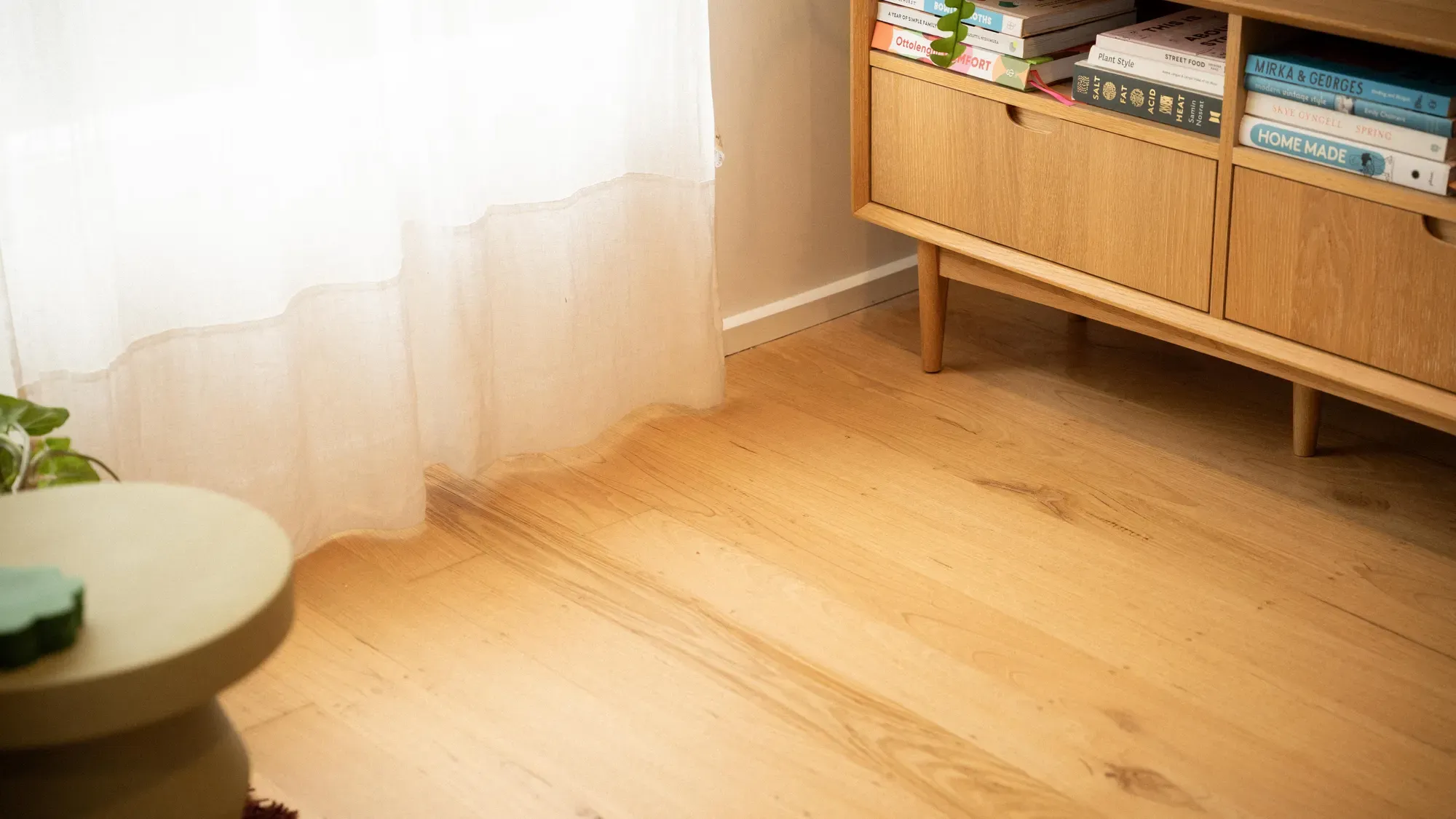 A timber sideboard against sheer curtains