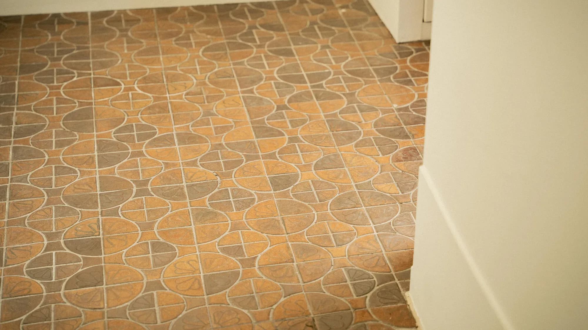 Patterned terracotta floor tiles in circles and petals