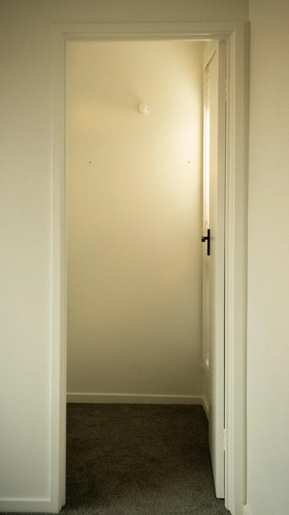 An open doorway onto a carpeted room